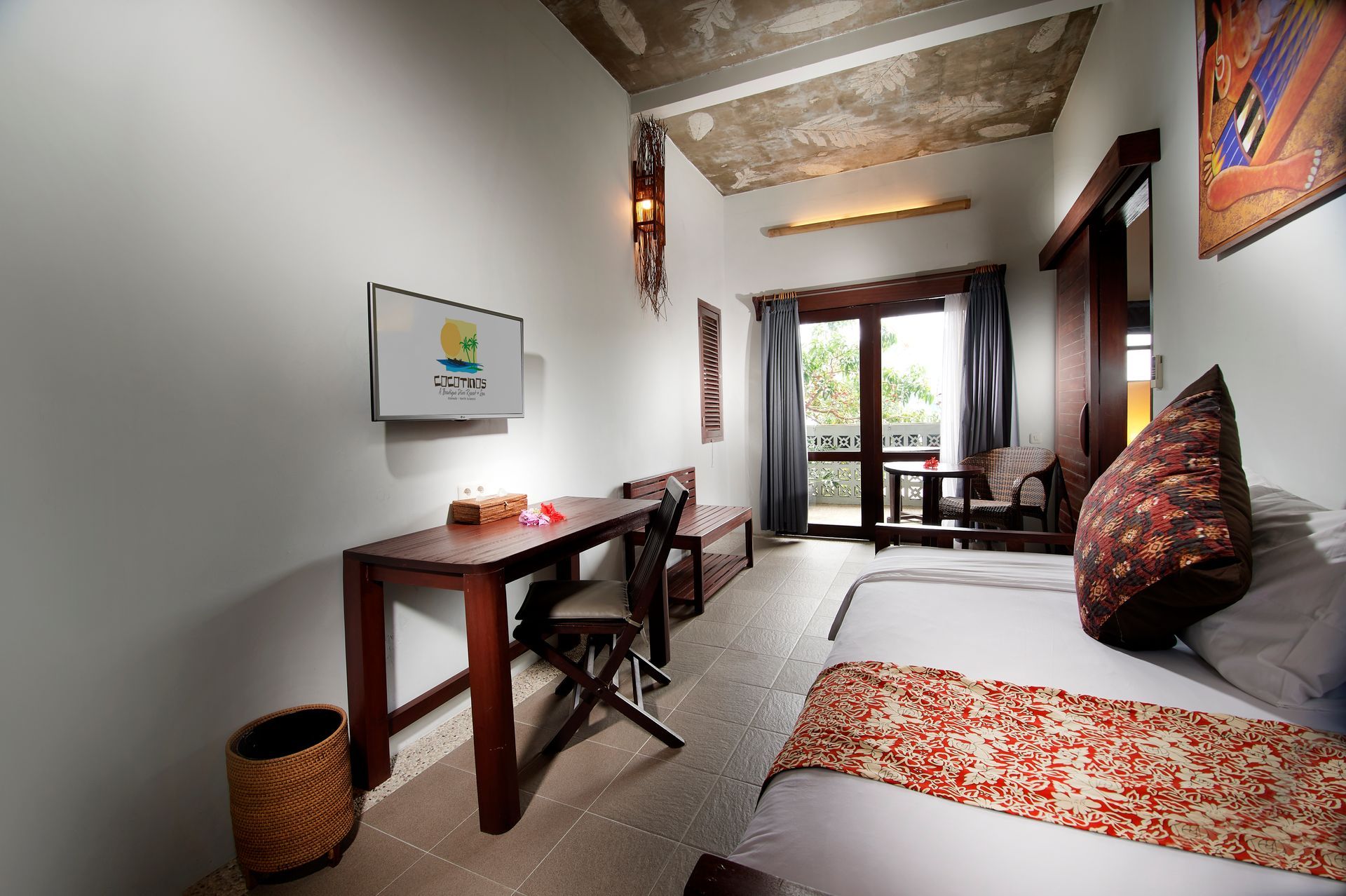 A hotel room with a bed , desk , chair and television.