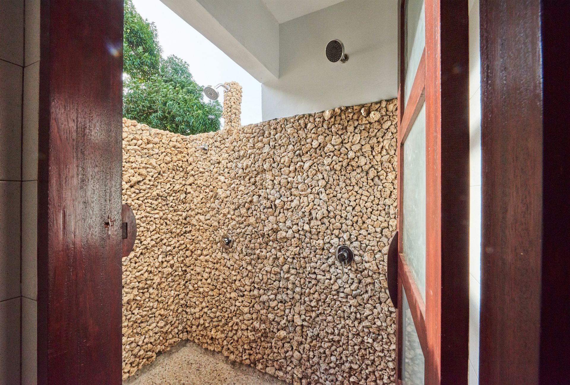 A bathroom with a stone wall and a shower.