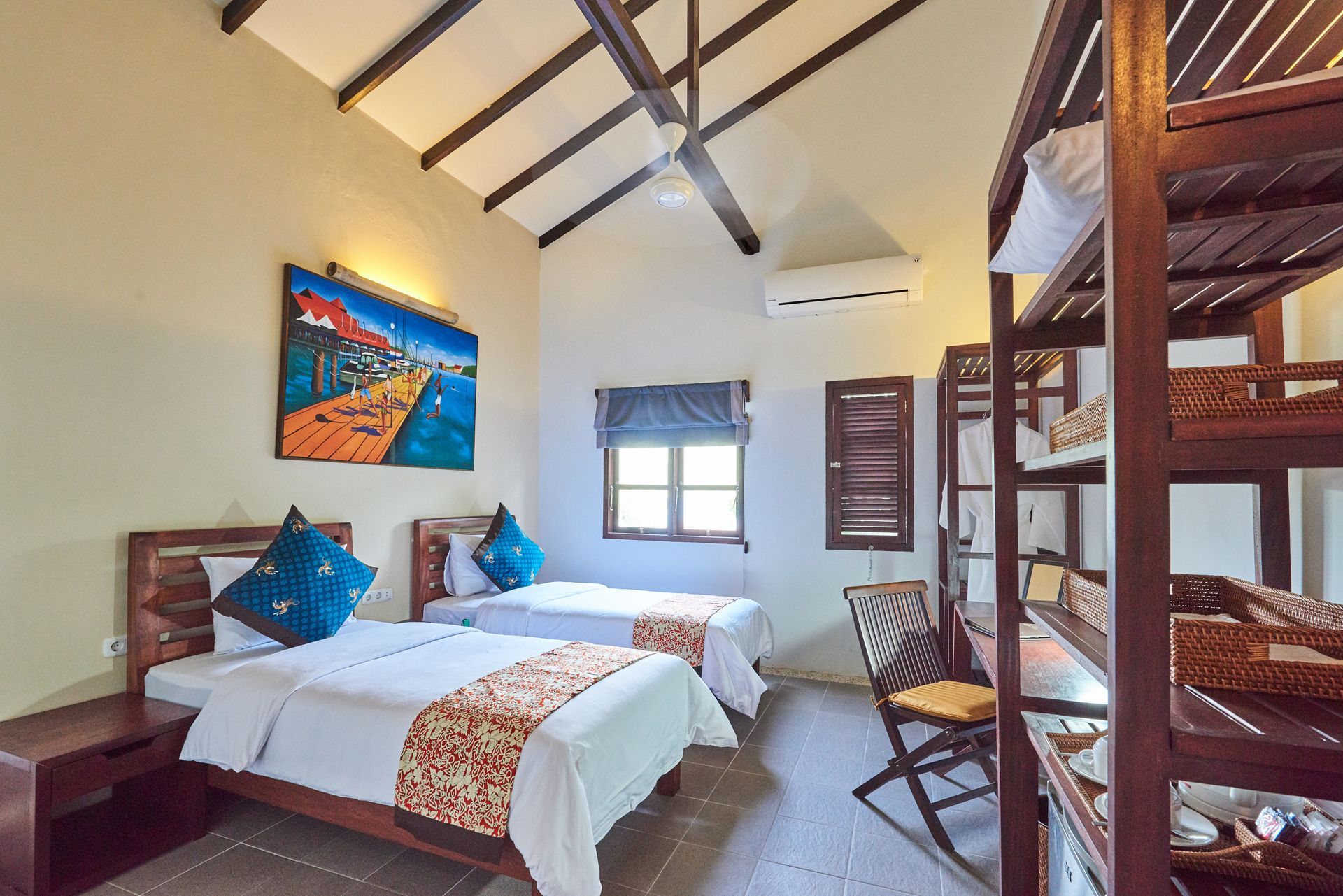 A hotel room with two beds and a bunk bed.