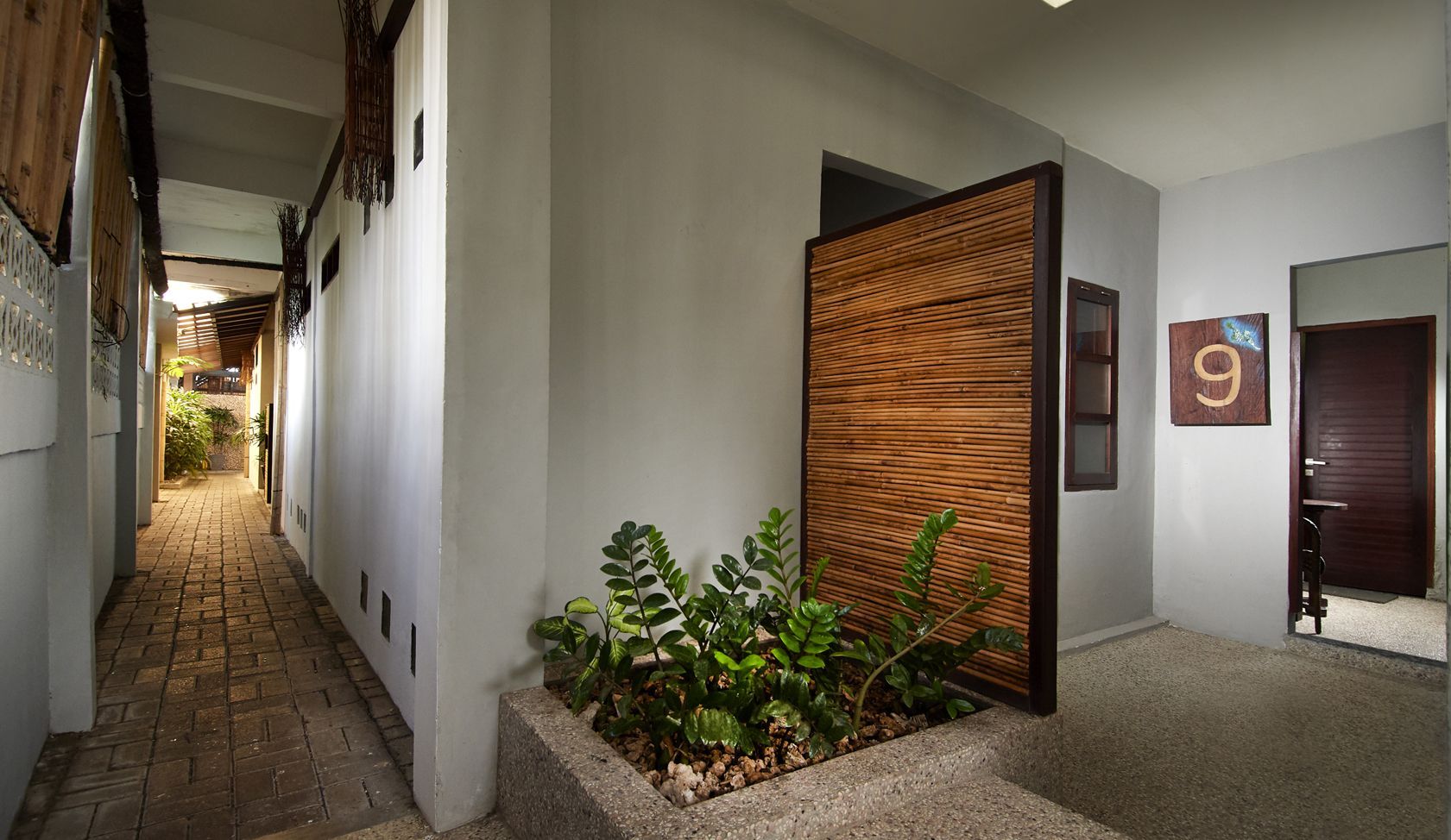 A long hallway with a plant in the middle of it
