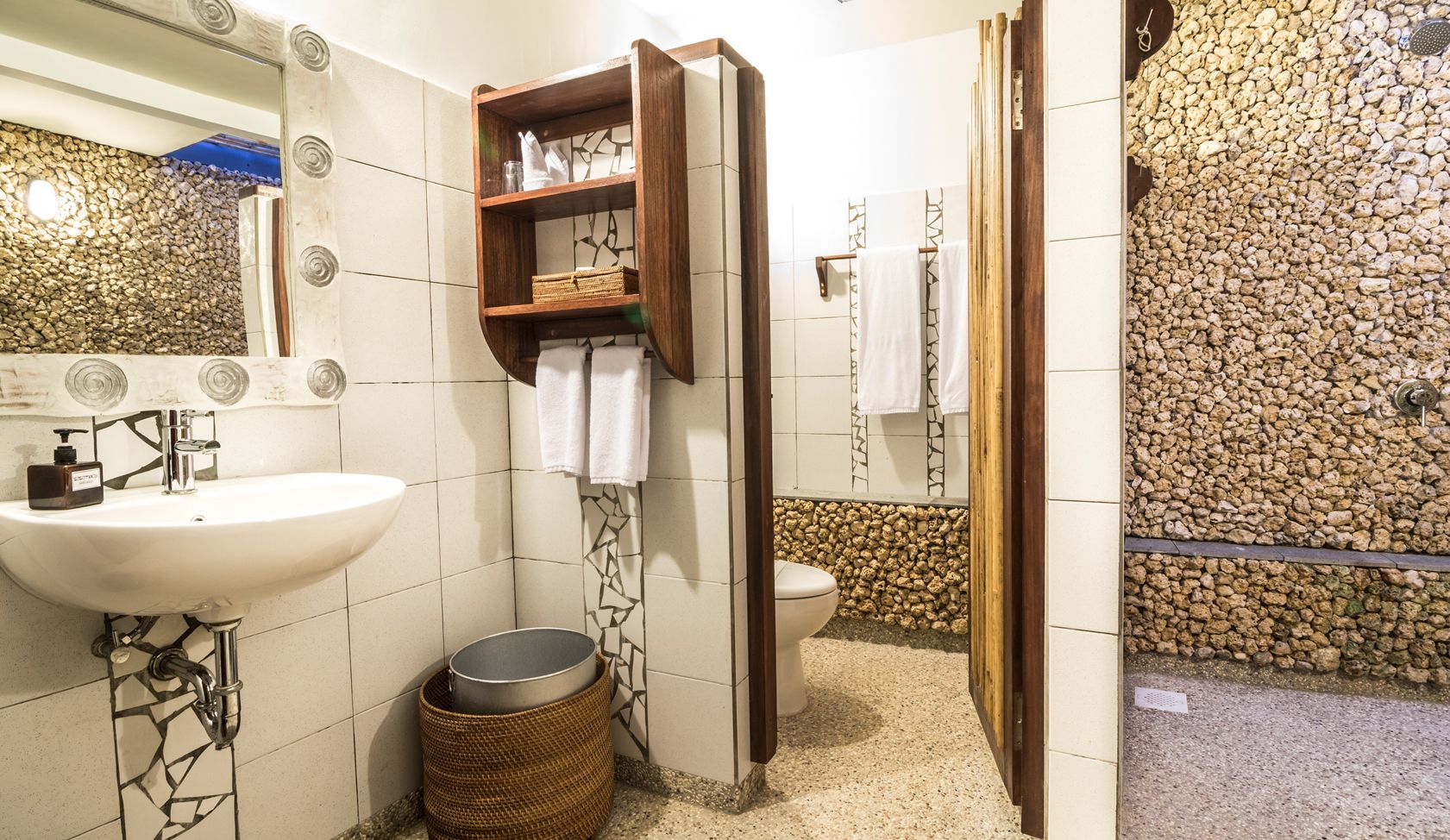 A bathroom with a sink , toilet , mirror and walk in shower.