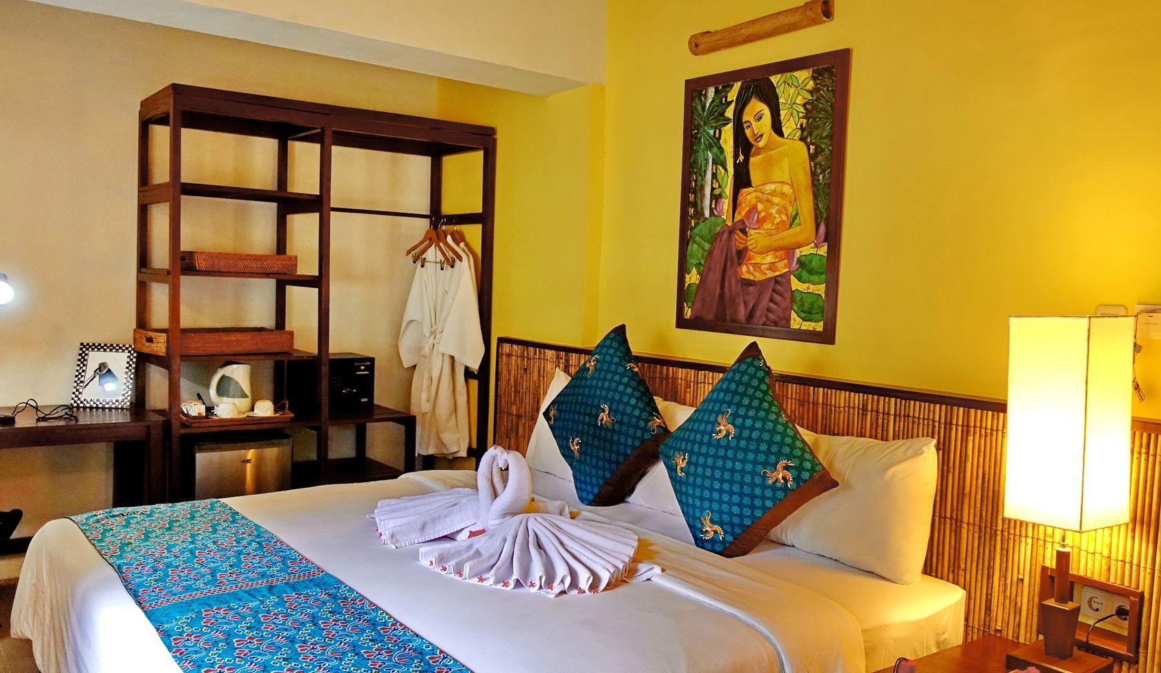 A hotel room with a large bed and a painting on the wall.