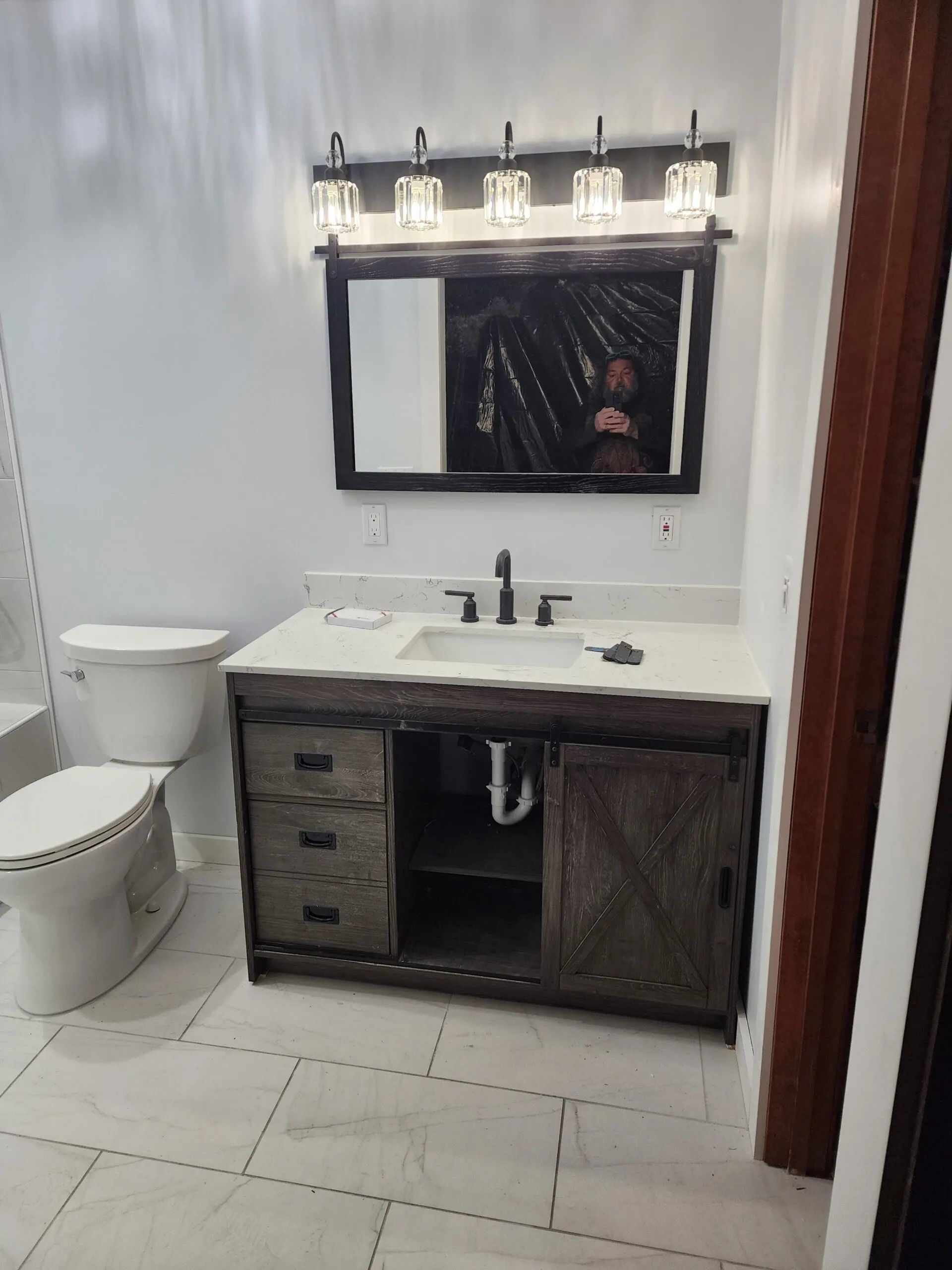 A bathroom with a sink , toilet and mirror.