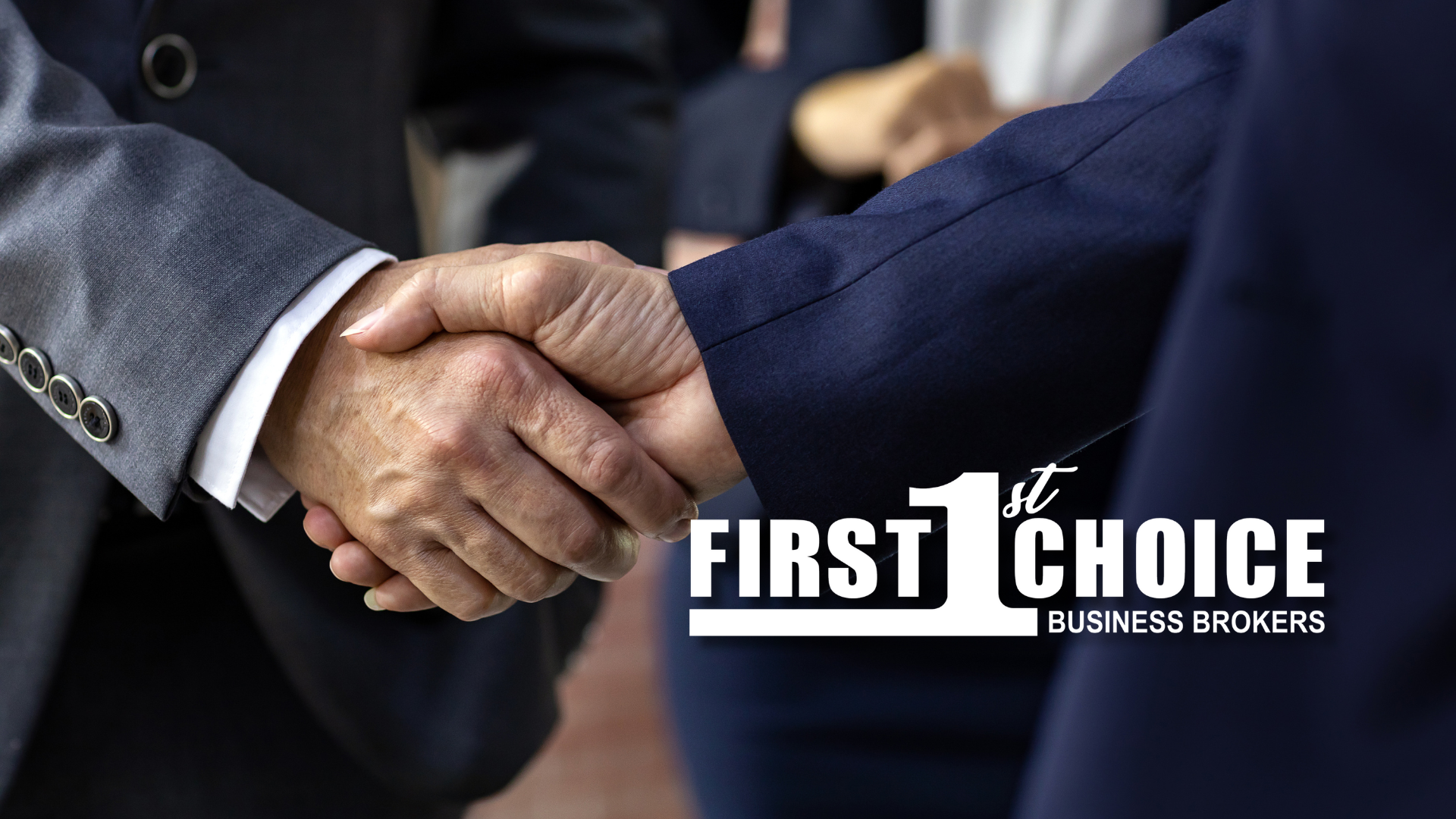 A man in a suit is shaking hands with another man in a suit.