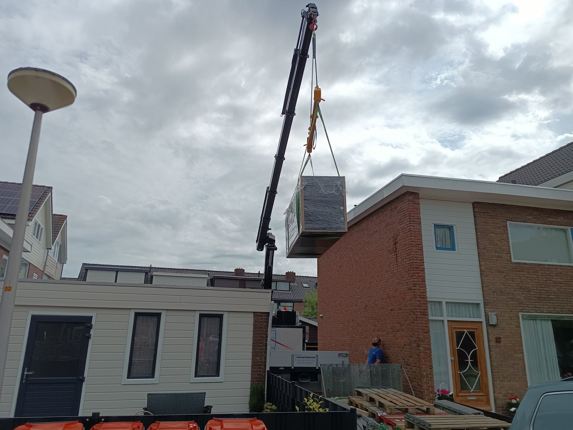 Een kraan tilt een aquarium over een schuur