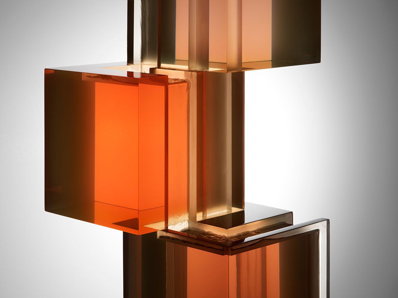 Abstracte compositie van doorschijnende oranje en gouden blokken, gestapeld en verschoven.