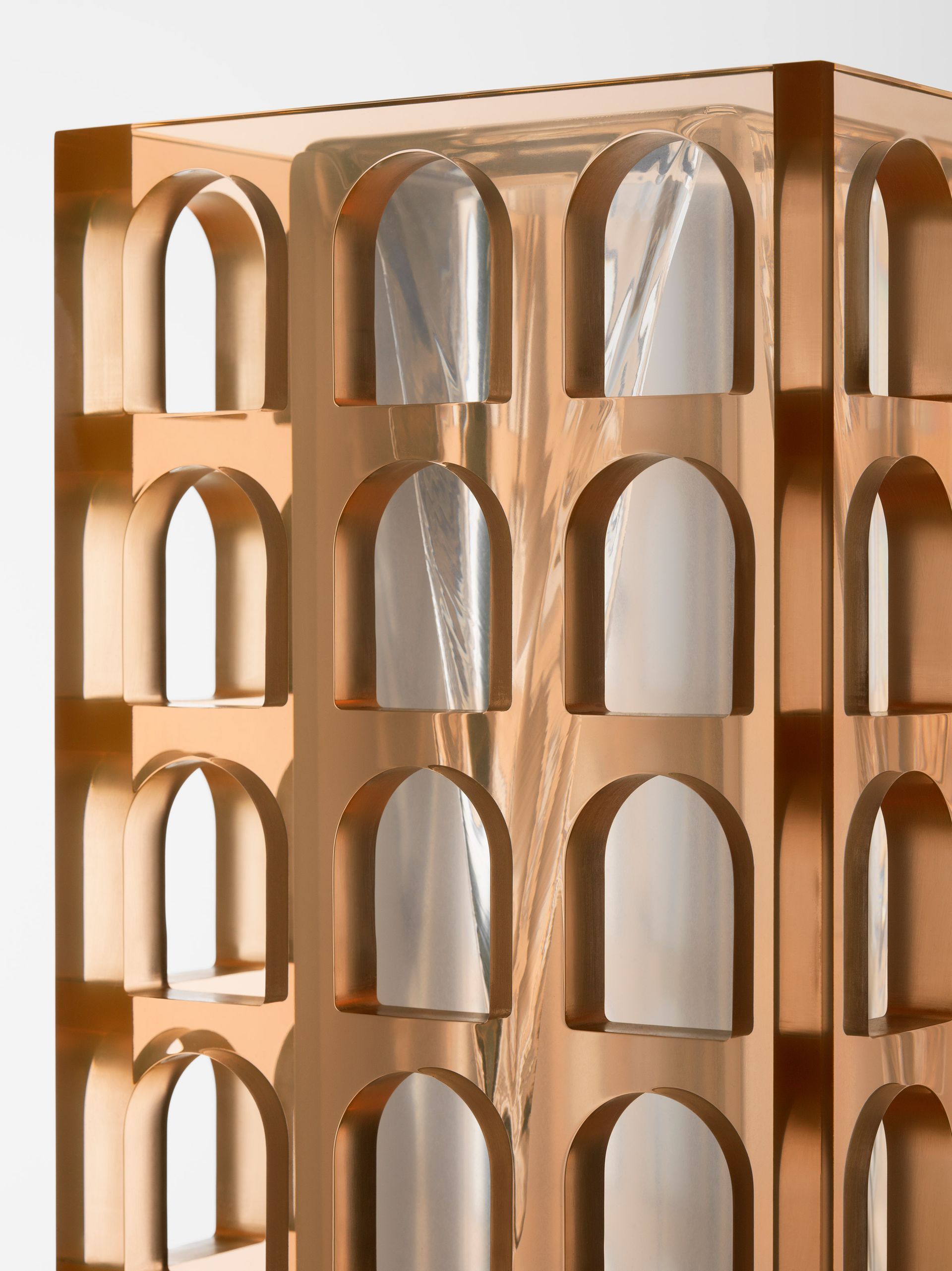 Goudkleurige structuur met gebogen openingen, waarvan sommige gevuld zijn met reflecterend materiaal.