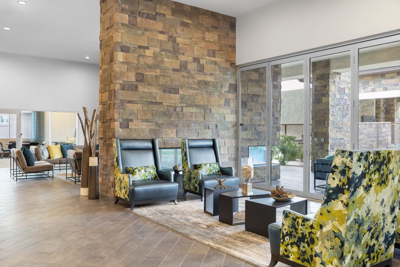Lobby lounge with stone accent wall, glass doors, and contemporary seating.