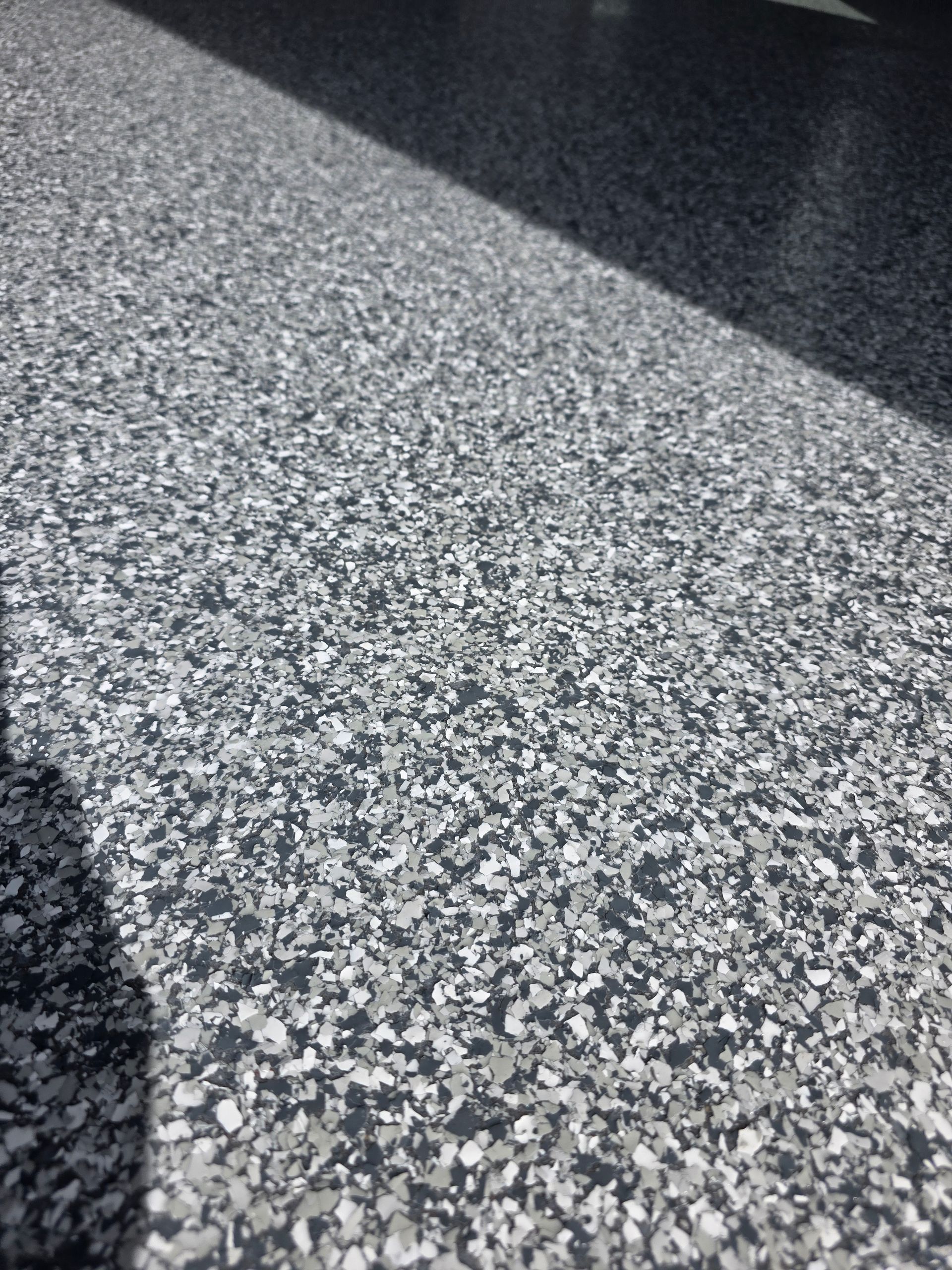 Person in green jacket working on a red semi-truck in a garage.