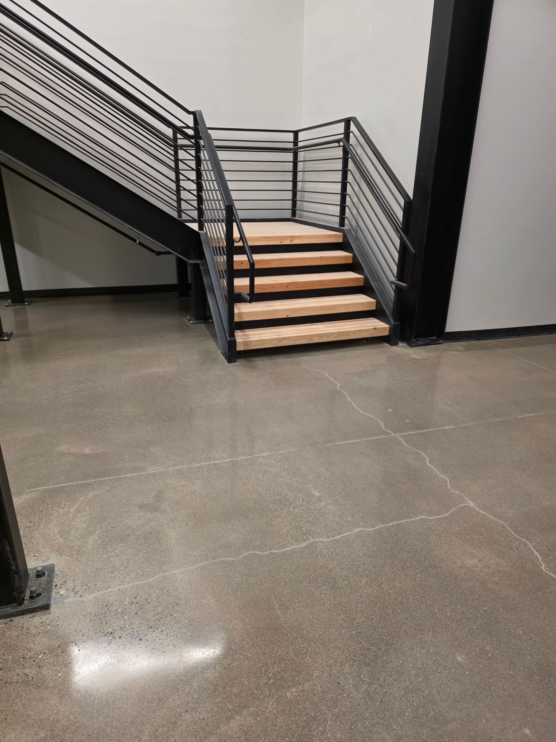 Red semi-truck in a dimly lit garage; a person stands near a lift.