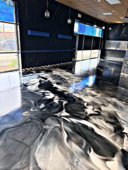 Garage with a blue and gray epoxy floor.  A door, water heater, and HVAC are visible.
