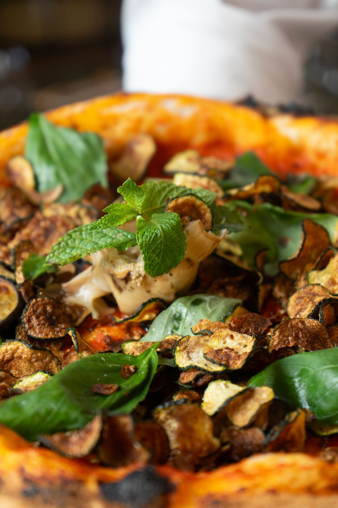 Primo piano di una pizza con verdure su un tavolo.