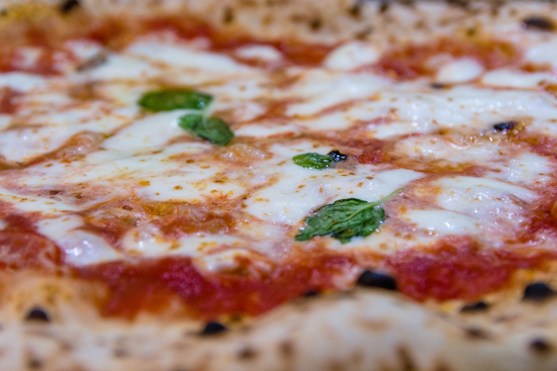 Primo piano di una pizza con salsa di pomodoro e formaggio.