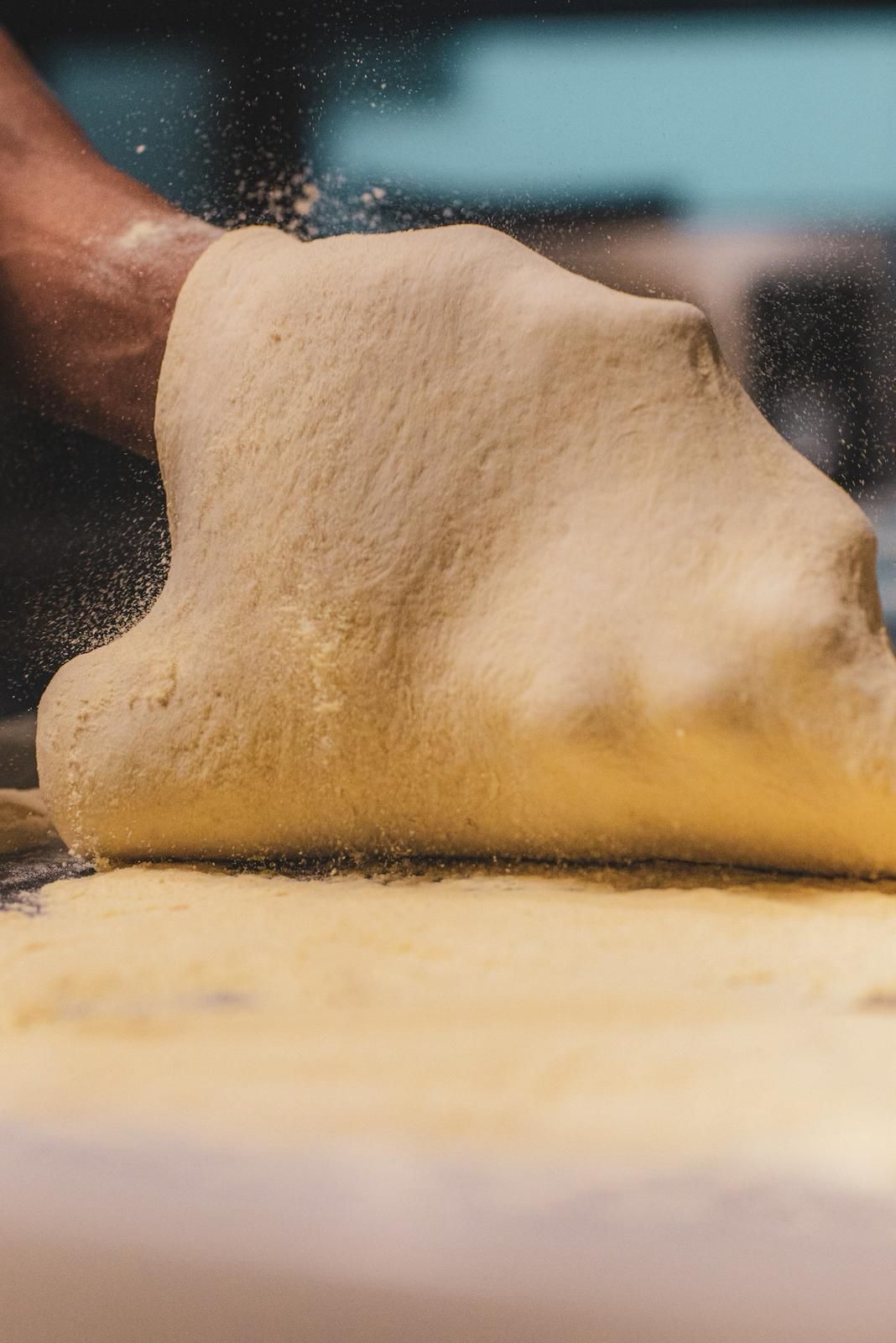 Primo piano di una pizza con prosciutto e formaggio su un piatto bianco.