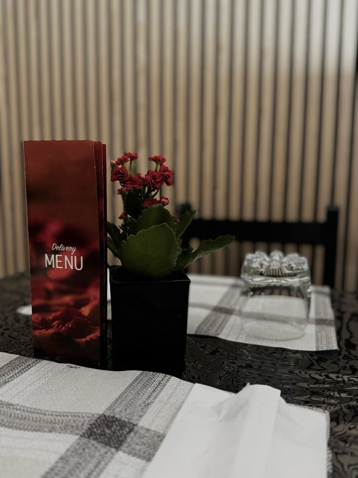 Un menù è appoggiato su un tavolo accanto a una pianta in vaso.