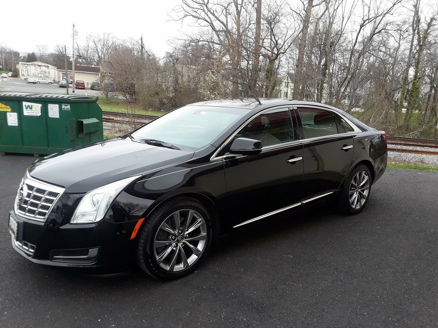 A close up of the side of a black limousine with chrome trim.