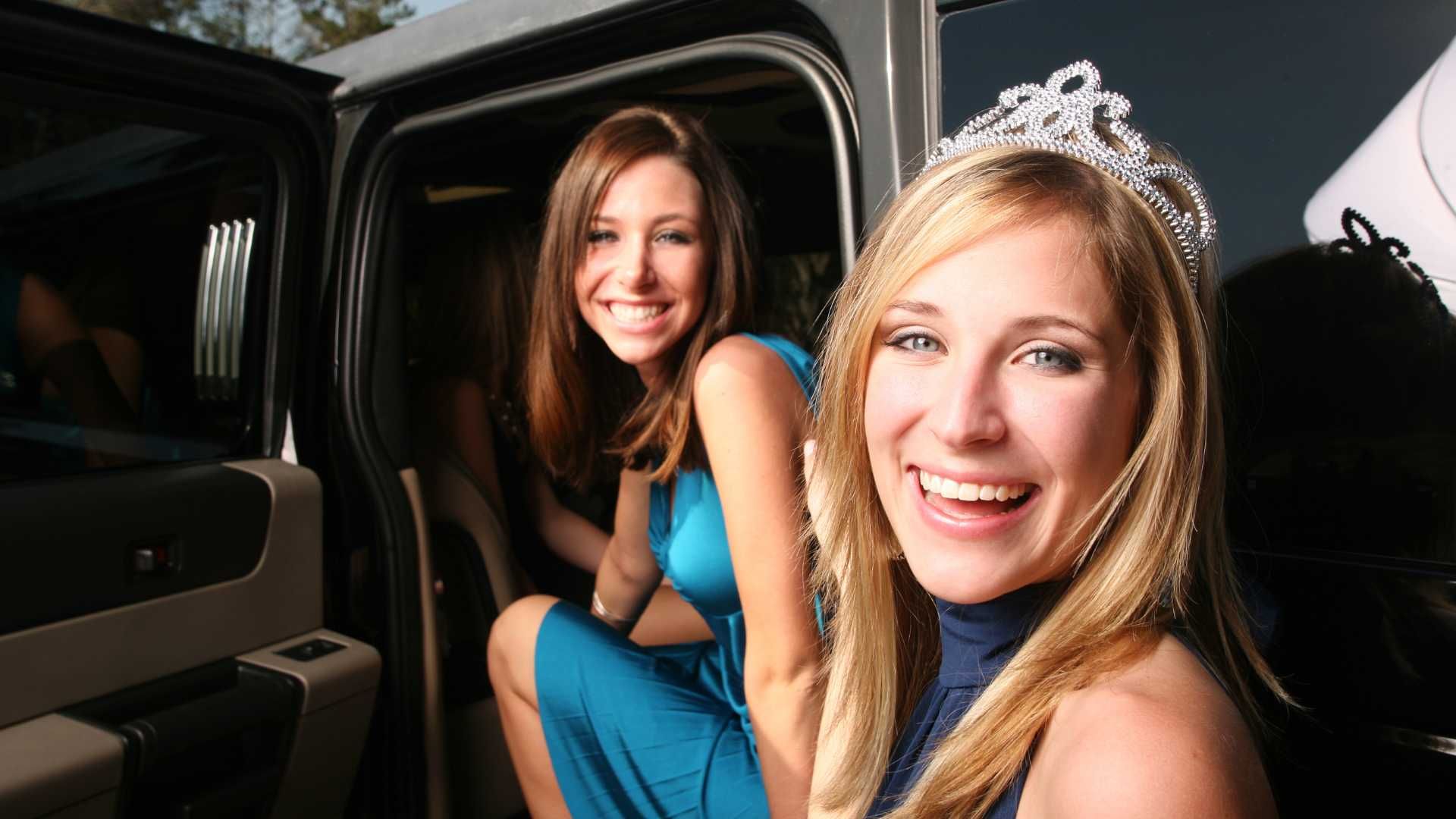 A group of people are sitting in a limousine toasting with champagne glasses.
