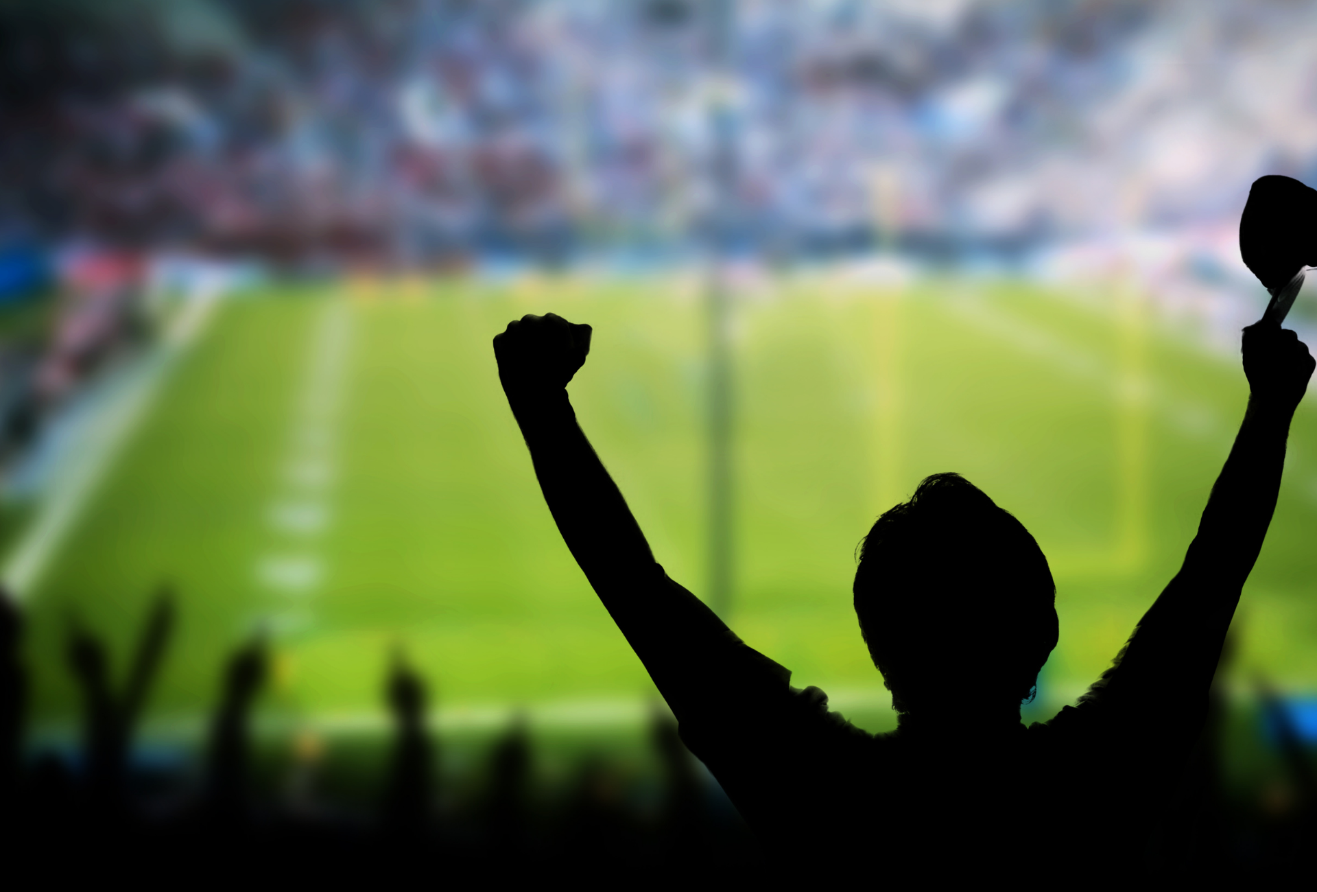 A silhouette of a person with their arms in the air