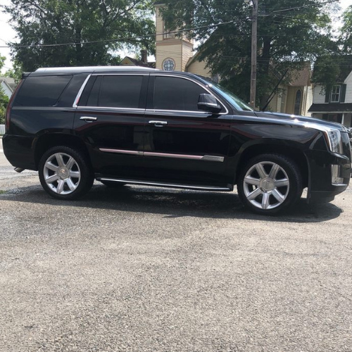 The back seat of a limousine with the sunroof open.