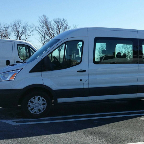 A group of people are sitting on a bus at night.