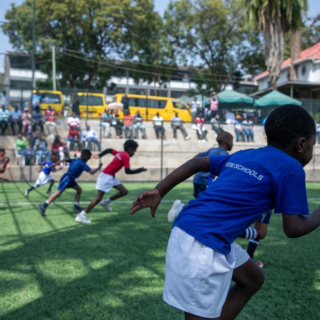 A boy in a blue shirt that says passionate is running on a field