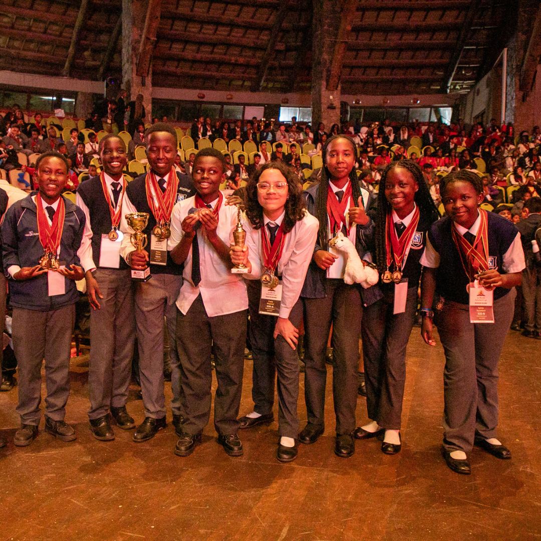 A group of people holding trophies in front of a crowd