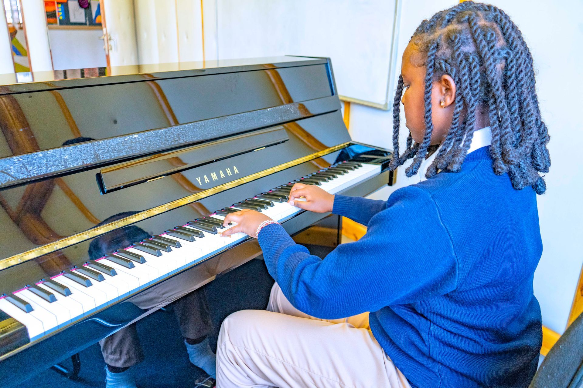 A woman is teaching a group of children in a classroom.