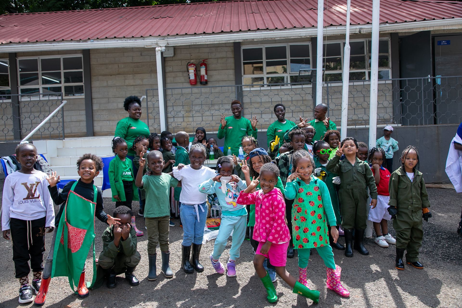 A group of children are posing for a picture in front of a building.