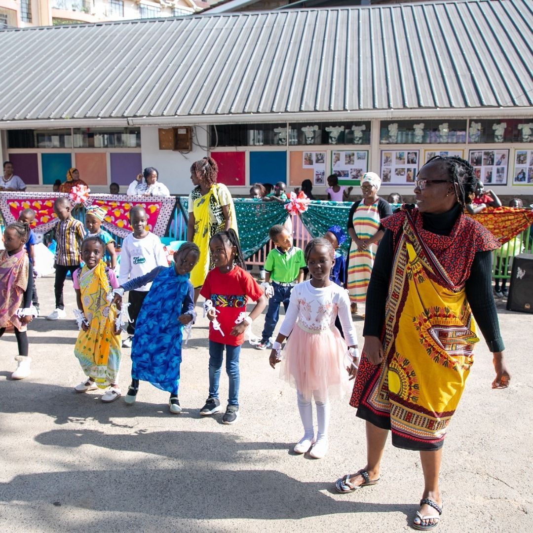 A group of children are standing in front of a building