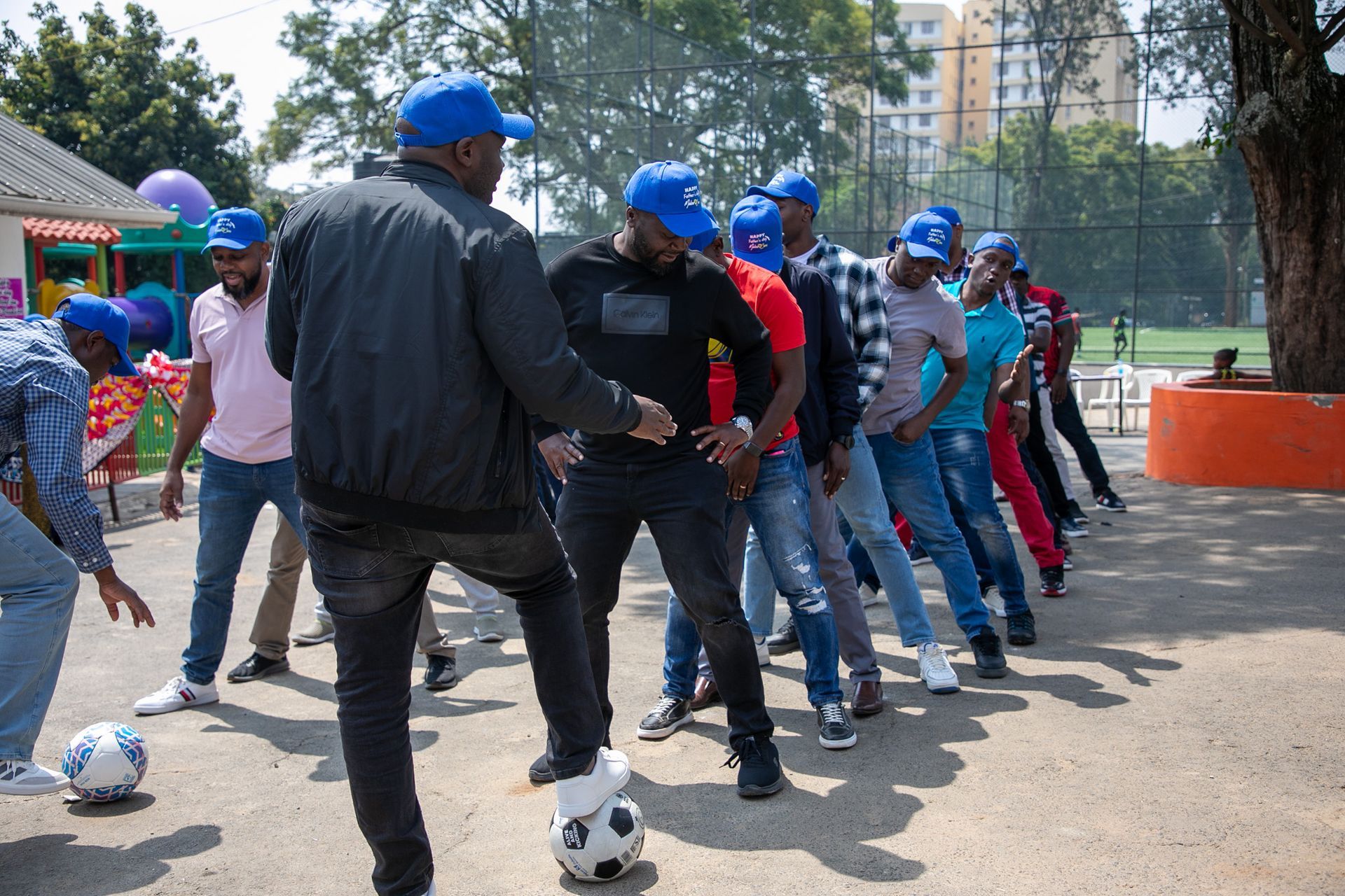 A group of men are standing around a soccer ball.