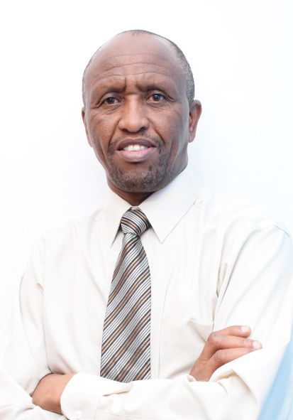 A man in a white shirt and tie with his arms crossed