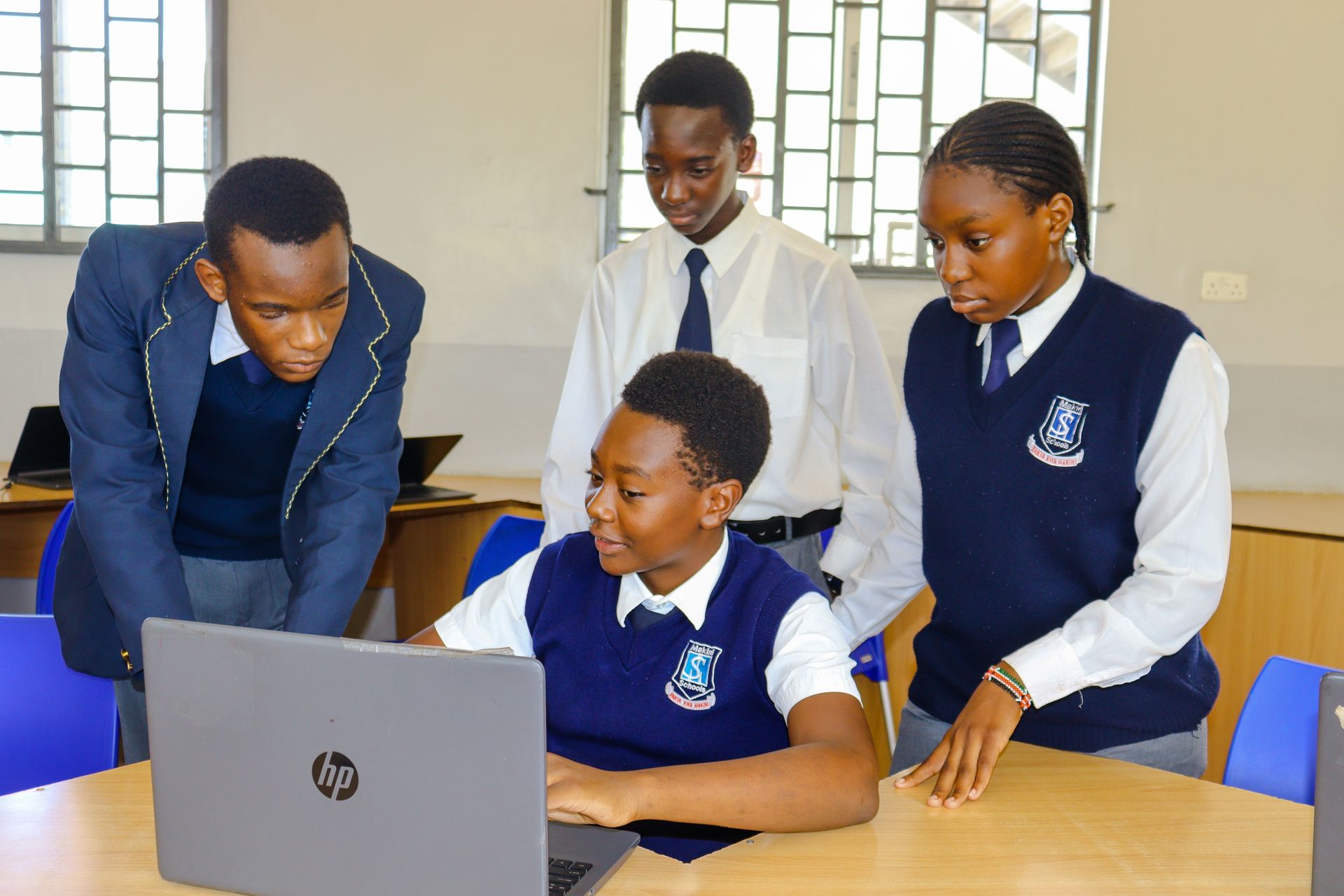 A woman is giving a presentation to a group of students in a computer lab.