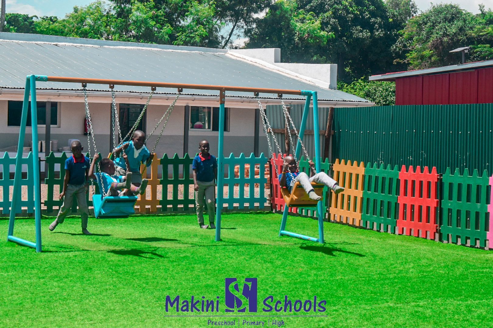 A group of children are playing on swings at makini schools