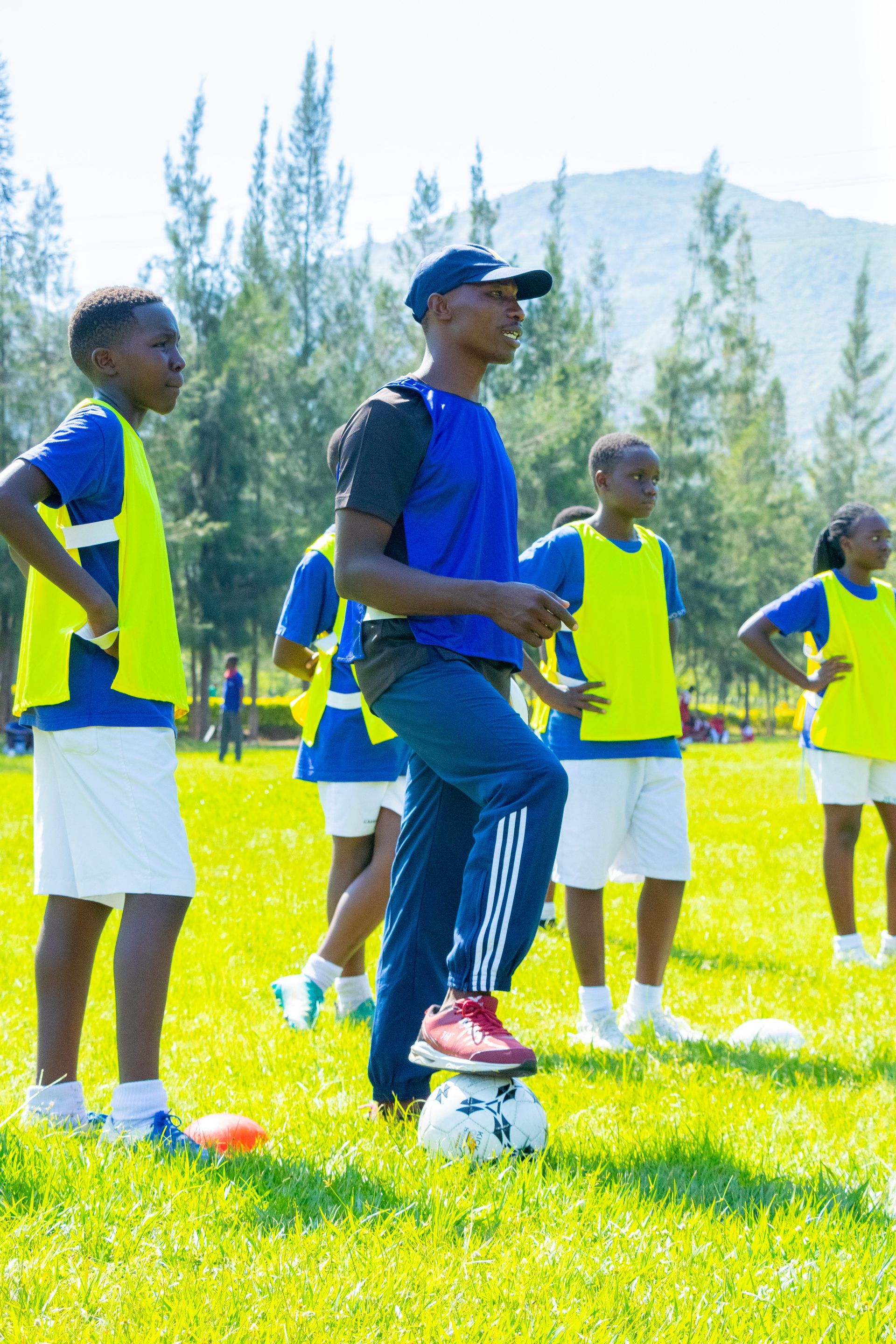 A man is teaching a girl how to play badminton.