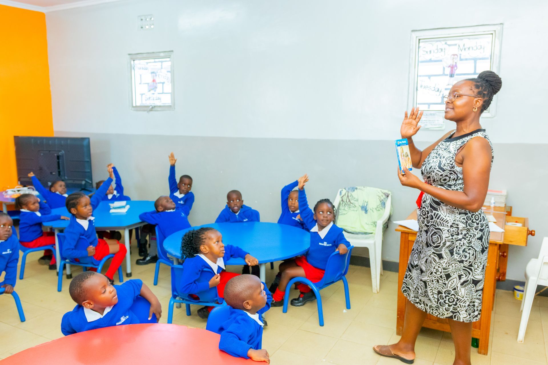 A teacher is teaching a group of children in a classroom.
