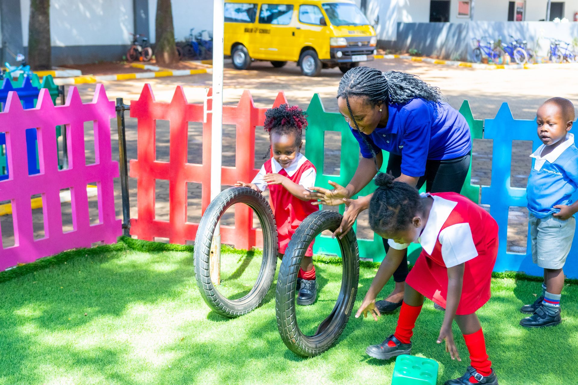 A group of children are playing with tires in a playground.