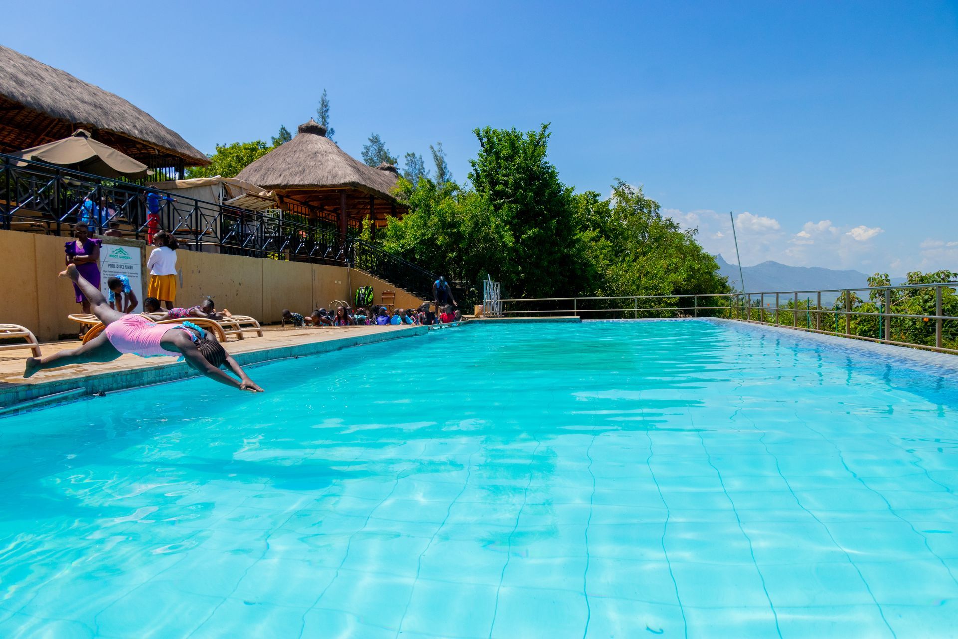 A woman is diving into a large swimming pool.