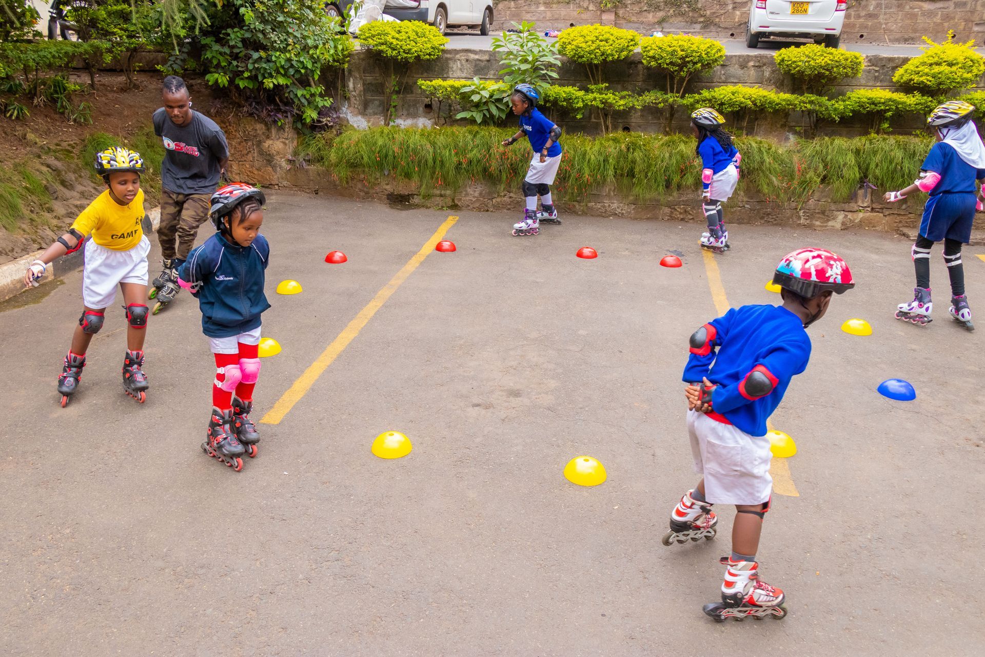 A group of children are rollerblading in a parking lot.