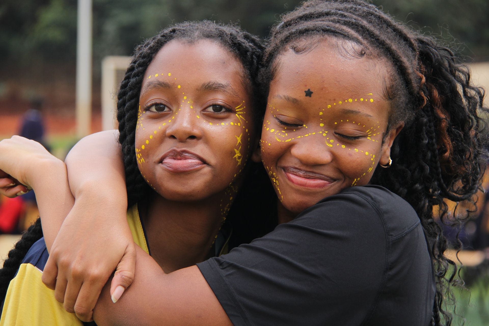 A group of children are planting a tree in the dirt.