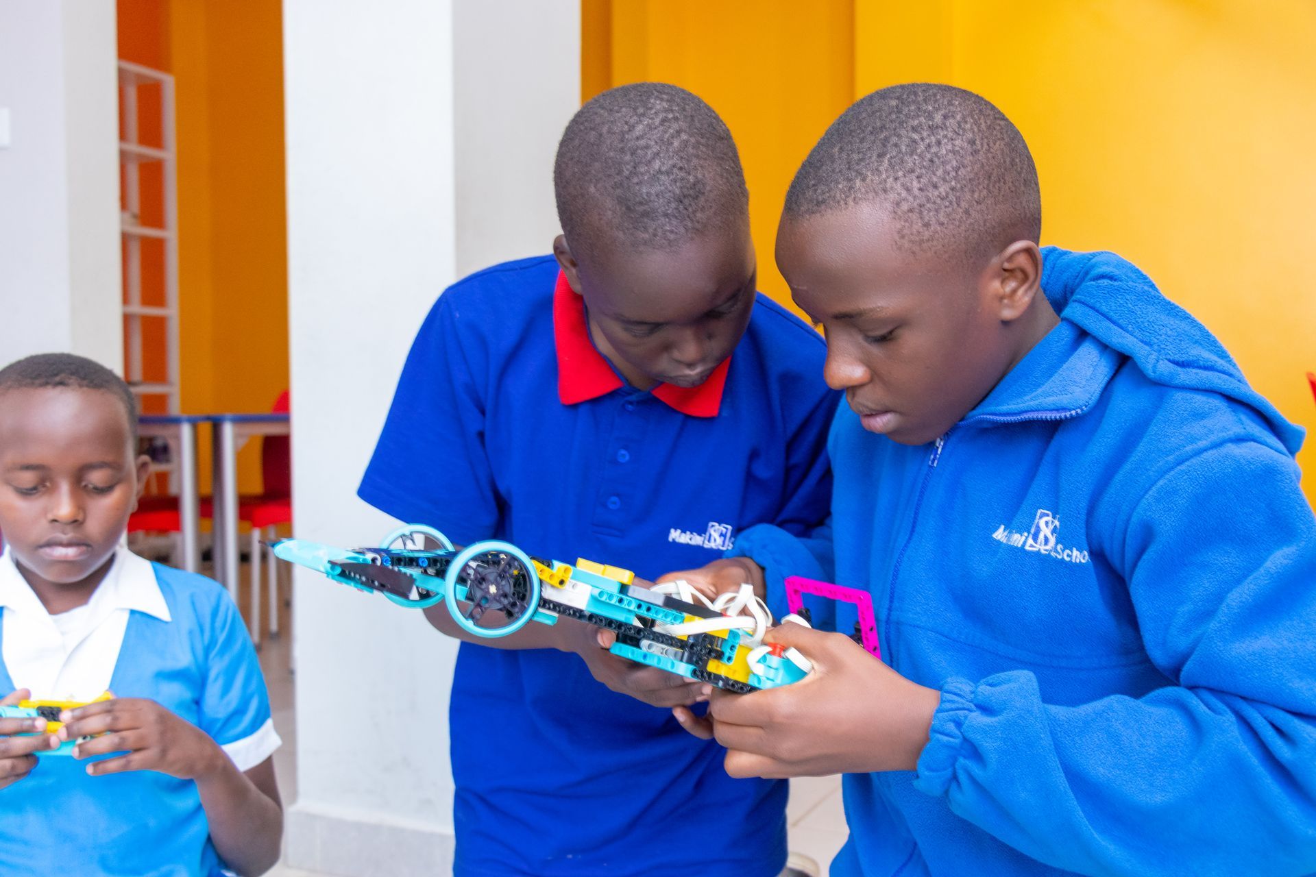 A group of young boys are playing with a toy car.