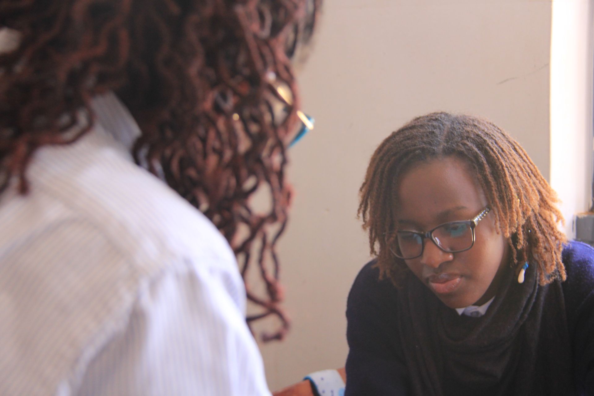 A playground with swings and a mural on the wall in front of a building.