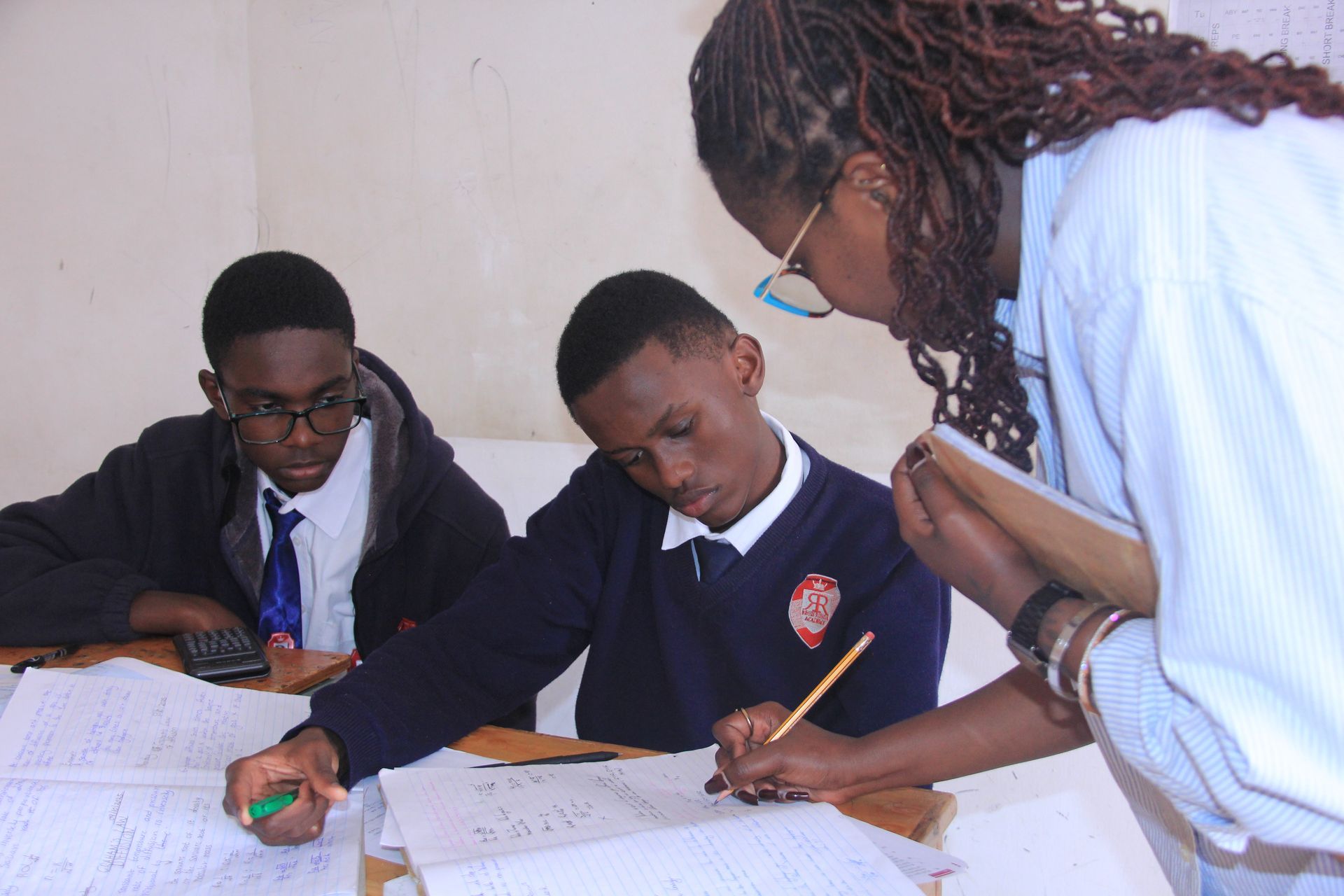 A playground with swings and a mural on the wall in front of a building.