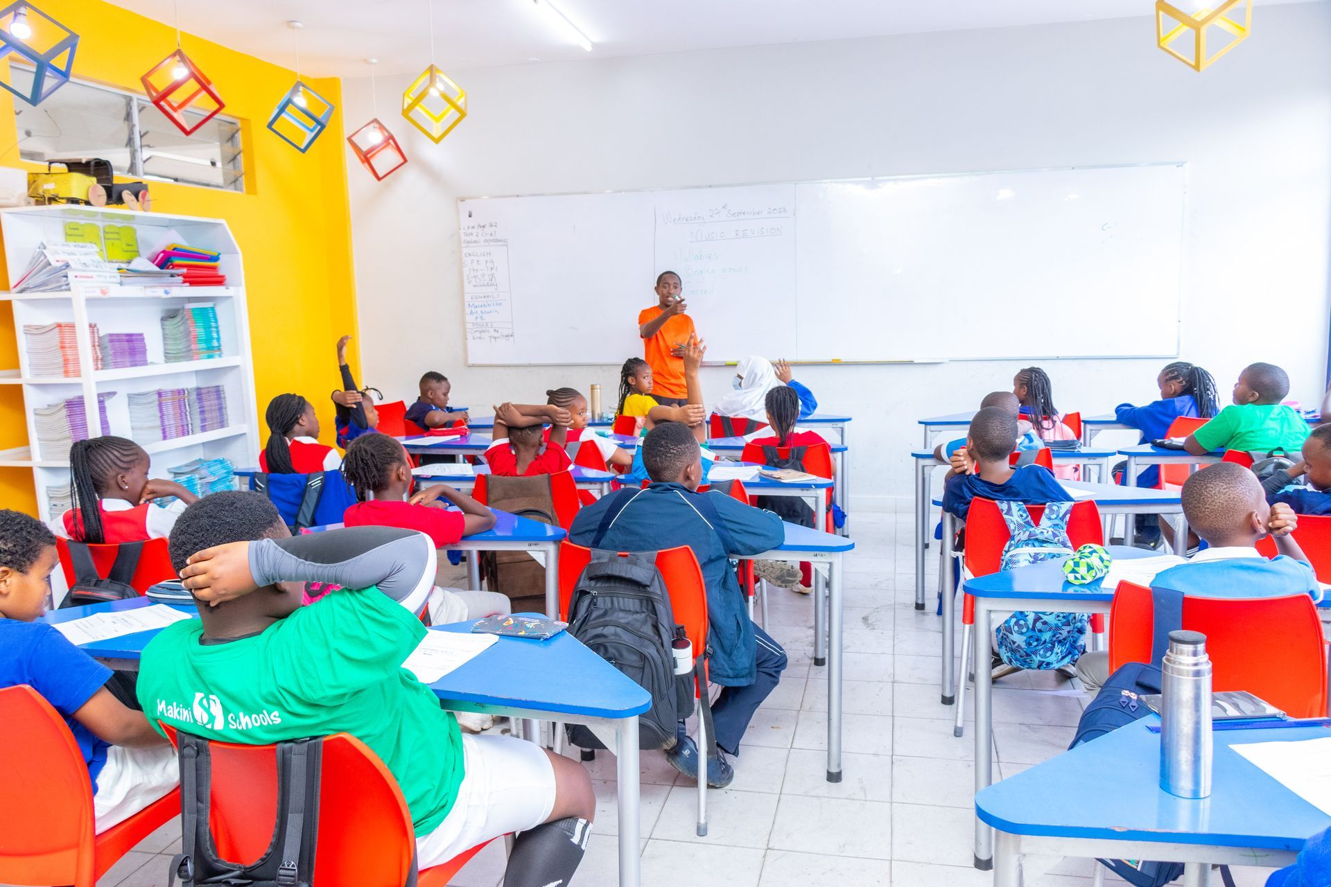 A group of children are sitting at their desks in a classroom.