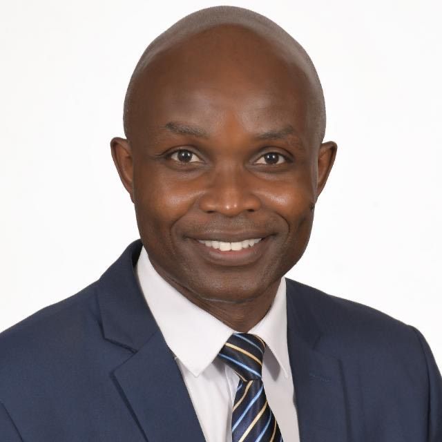 A man in a suit and tie is smiling for the camera