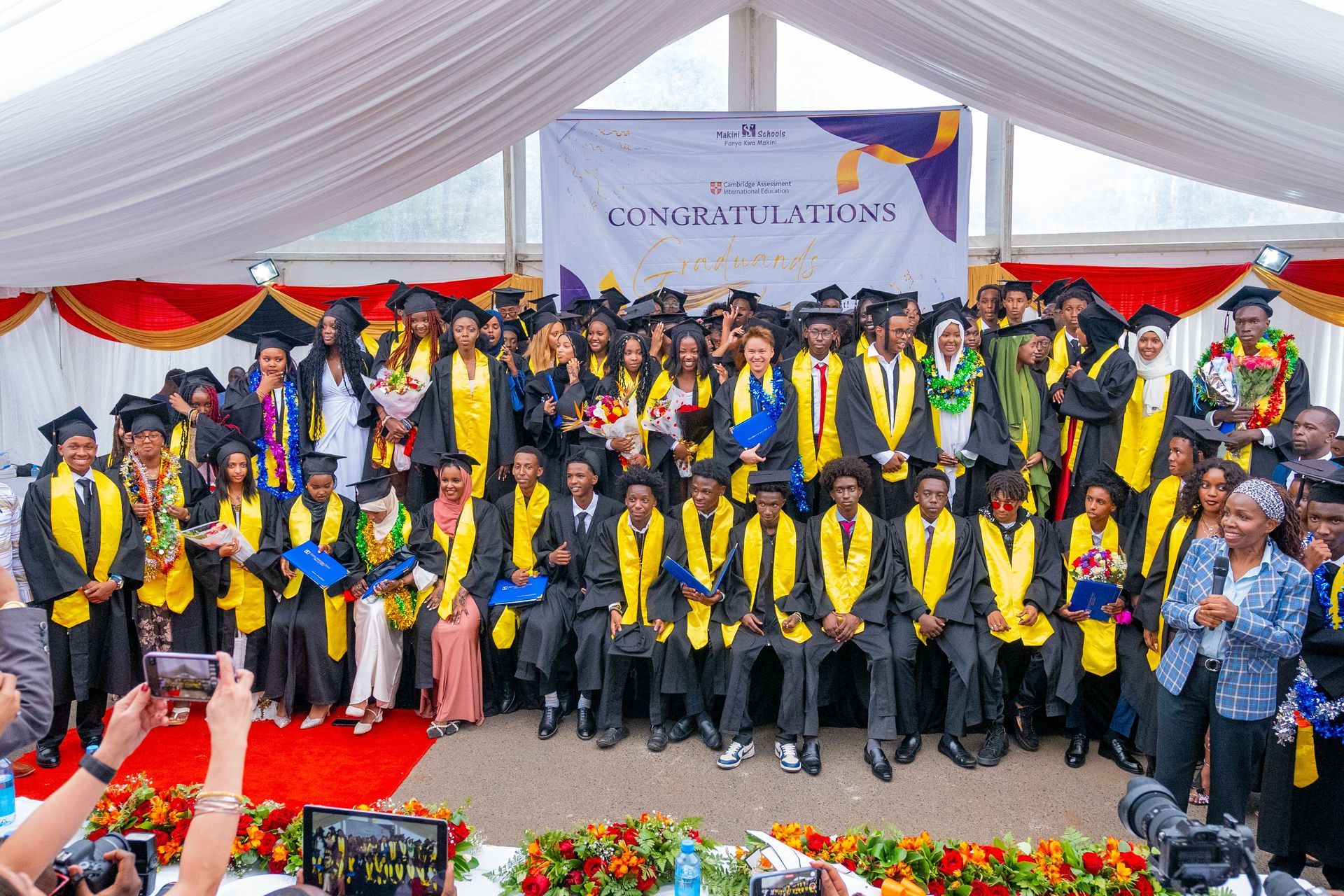 A group of graduates are posing for a picture at a graduation ceremony.