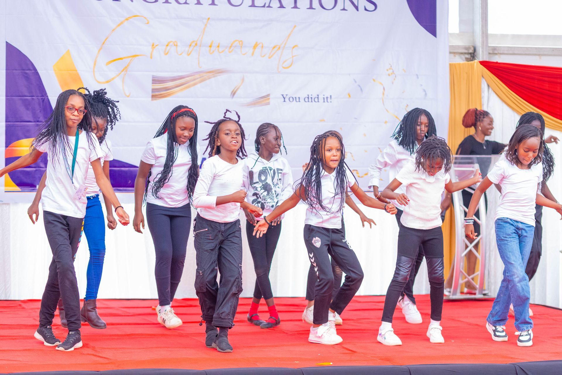A group of young girls are dancing on a stage.