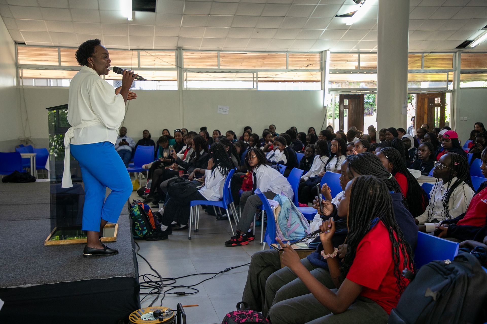 A woman singing into a microphone in front of a crowd