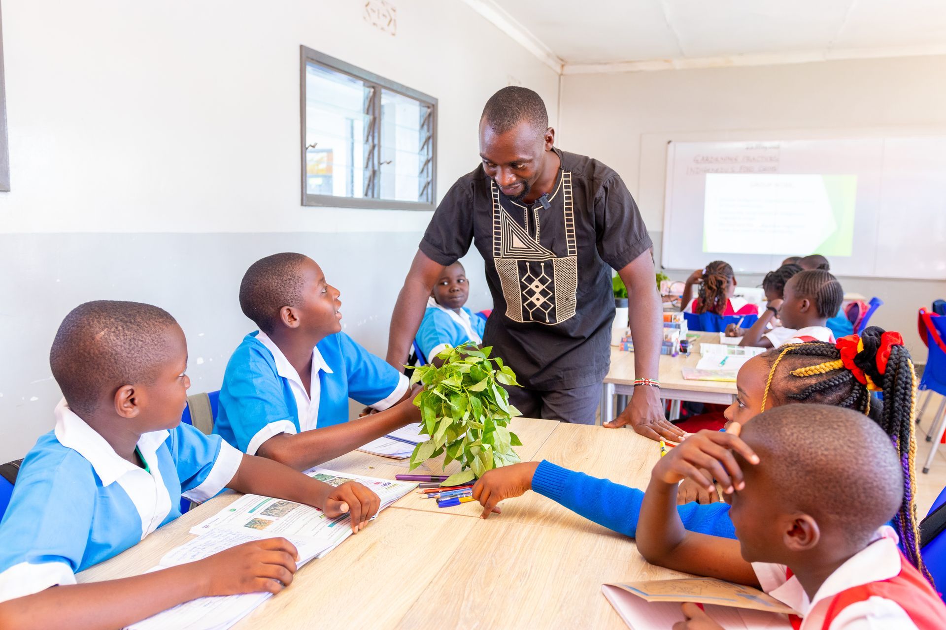 A teacher is teaching a group of children in a classroom.
