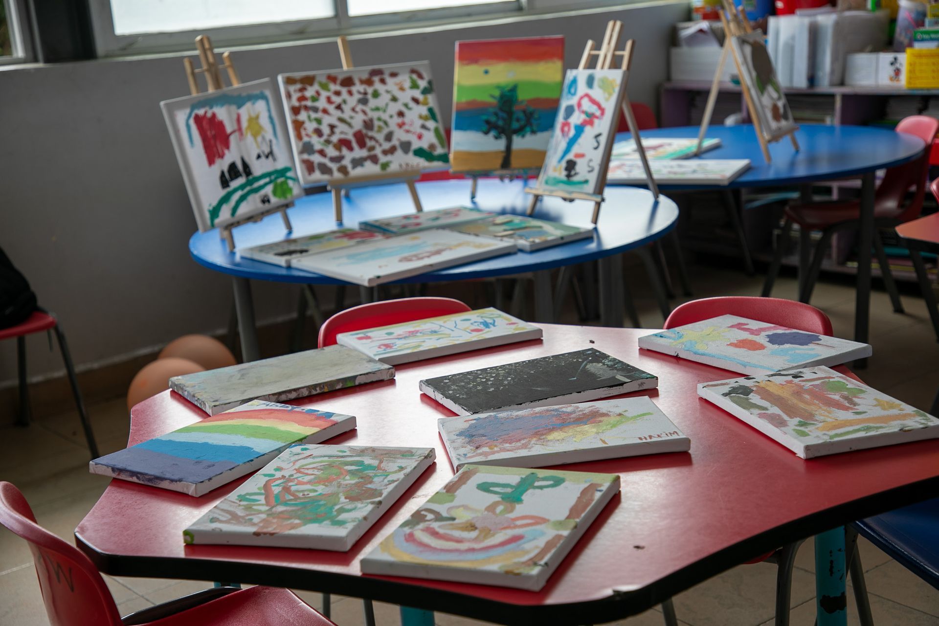 A table with paintings on it in a classroom