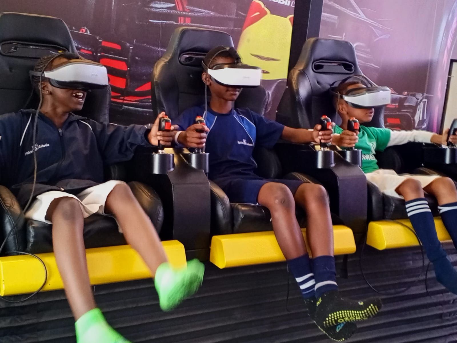 A group of children wearing virtual reality headsets on a roller coaster ride